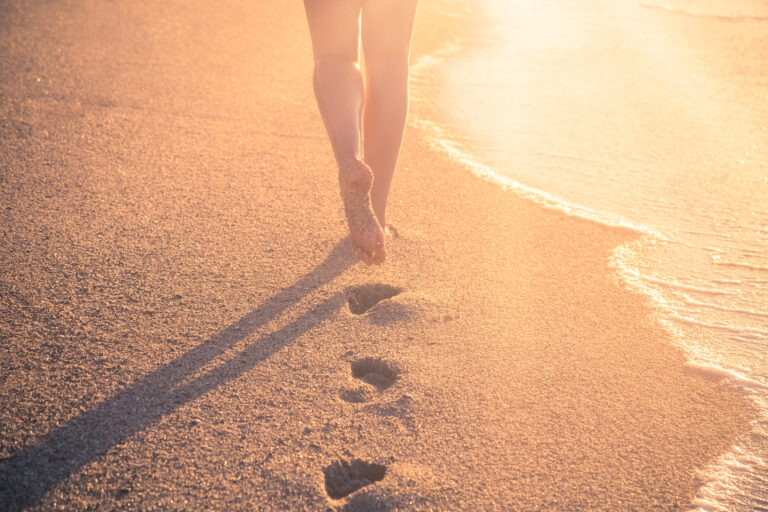 Woman walking outside barefoot while grounding