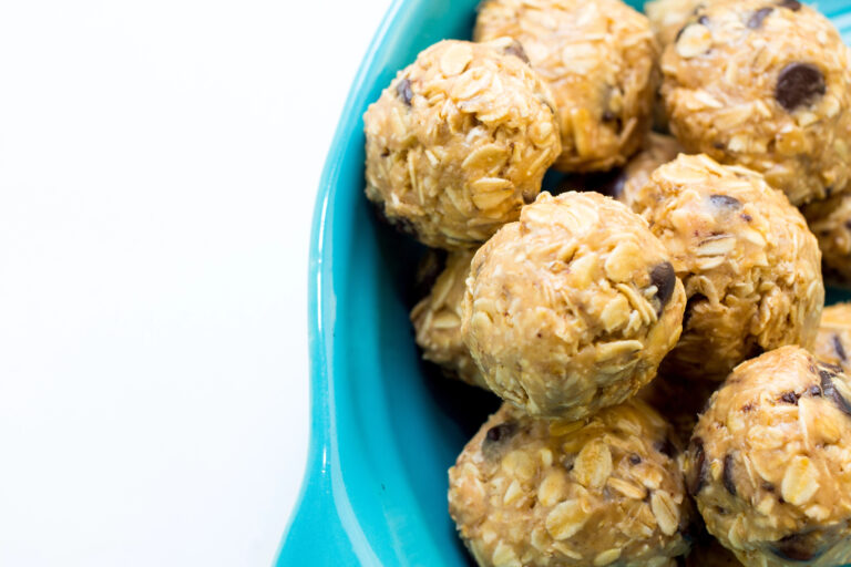 Homemade no-bake protein balls made with oats, peanut butter, flaxseed, and chocolate chips in a blue bowl